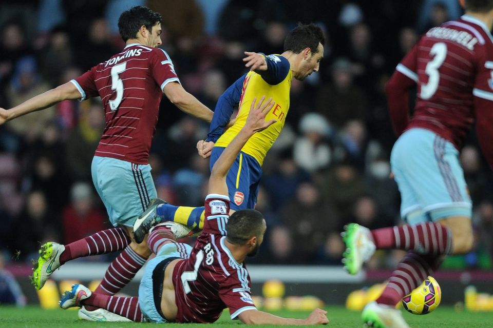 West Ham United's Winston Reid fouls Arsenal's Santi Cazorla for a penalty