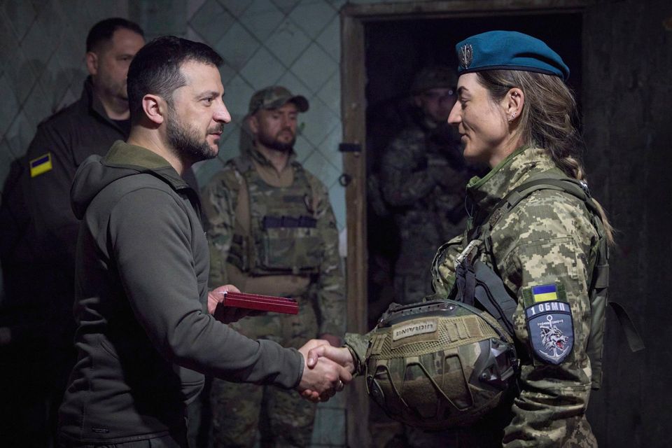 In this photo provided by the Ukrainian Presidential Press Office, Ukrainian president Volodymyr Zelenskyy shakes hands with a service woman during an awarding ceremony as he visits the Donetsk region, Ukraine, Tuesday, May 23, 2023. (Ukrainian Presidential Press Office via AP)