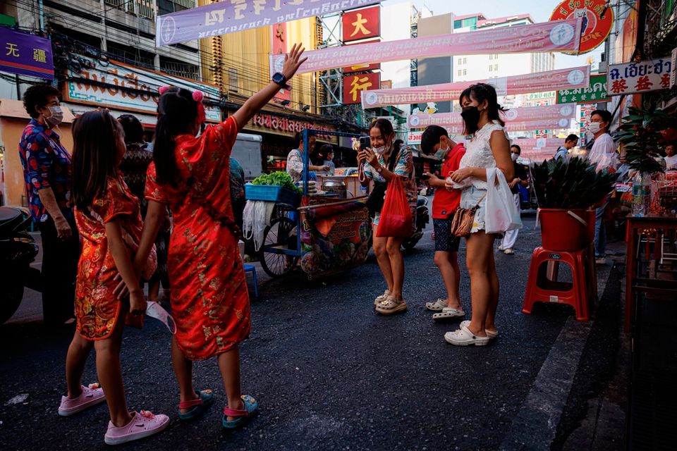 A family takes photos wearing traditional holiday clothing ahead of Chinese New Year celebrations in Bangkok, Thailand. Photo: Andre Malerba/Bloomberg