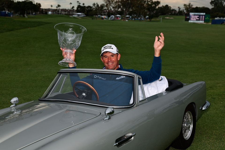 Padraig Harrington of Ireland poses for a photo with the winners trophy in a miniature Aston Martin
