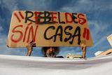 thumbnail: A demonstrator holds a sign that reads "rebels with out a house", during a protest against mass tourism in Palma de Mallorca on May 25. REUTERS/Juan Medina