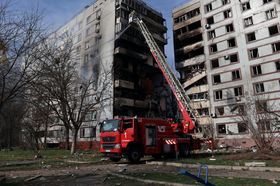 A firefighter puts out a fire after a Russian missile hit a residential multi-storey building in the southeastern city of Zaporizhzhia, Ukraine (Kateryna Klochko/AP)