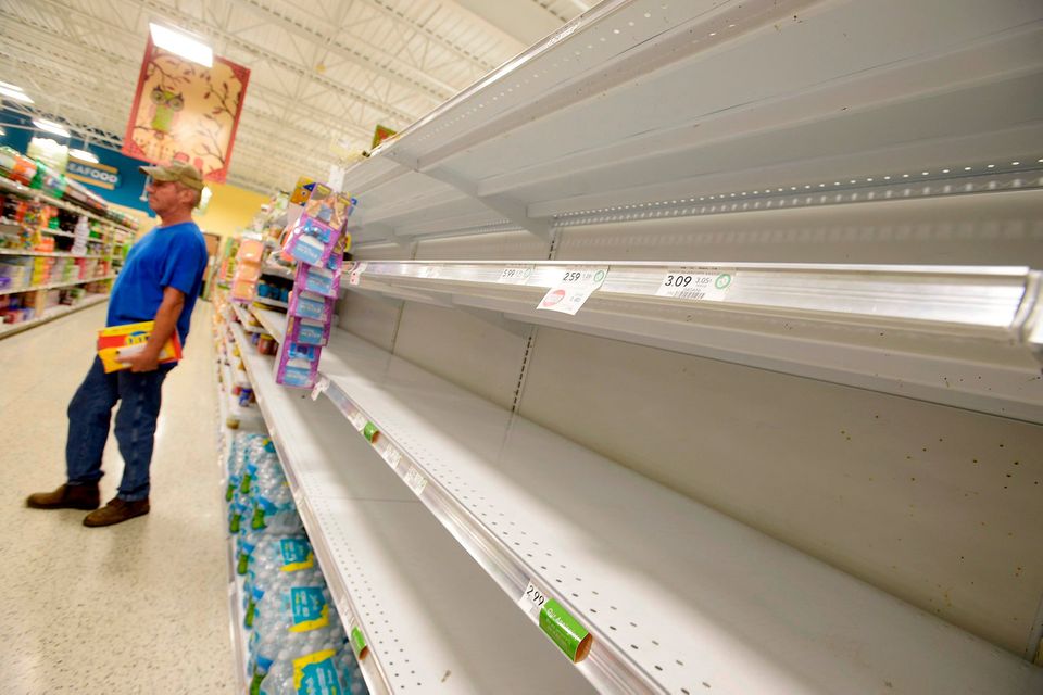Shelves formerly holding water bottles sit empty at a supermarket before the arrival of Hurricane Matthew in South Daytona, Florida