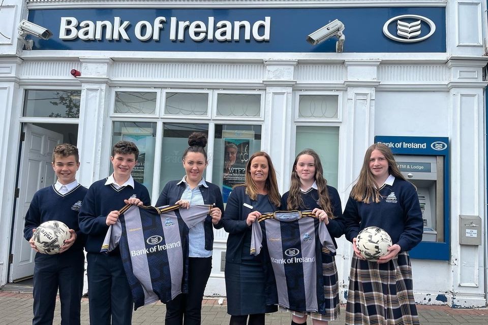 Isaac Carcone, Matthew Ryan, Lucy Tyndall and Faith Cassidy Canavan are presented with the new Greystones Community College football jerseys by Bank of Ireland Greystones staff.