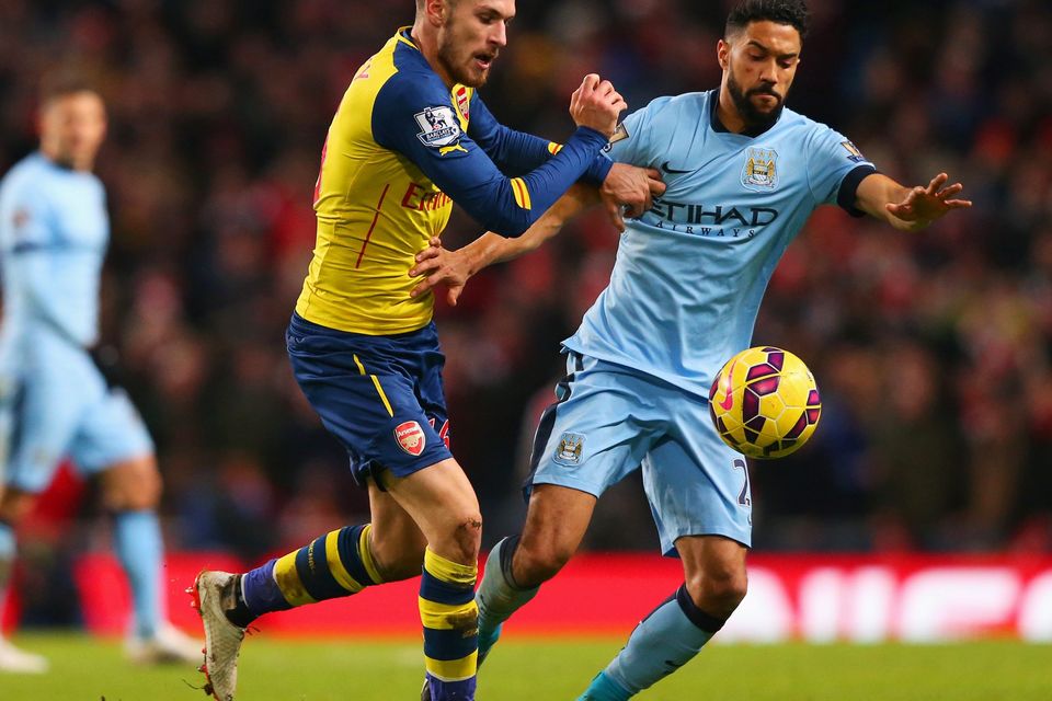 Aaron Ramsey of Arsenal battles with Gael Clichy