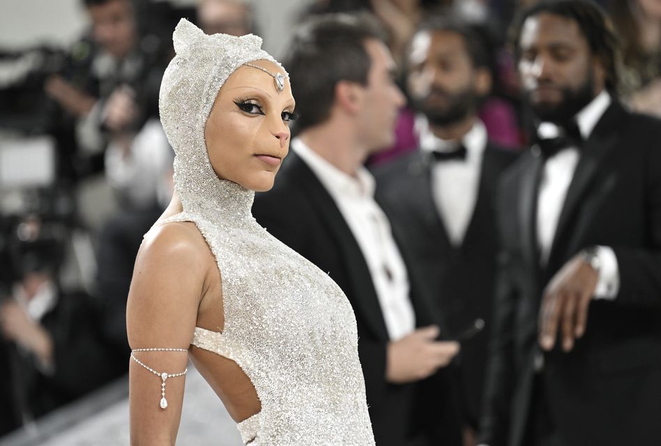 Doja Cat wore cat-inspired prosthetics and a silver skintight gown (Photo by Evan Agostini/Invision/AP)