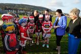 thumbnail: Michelle O'Neill (right) and Deputy First Minister Emma Little-Pengelly (second right) speak to young hurlers during a visit to St. Paul's GAA club in west Belfast. Photo: Niall Carson/PA Wire