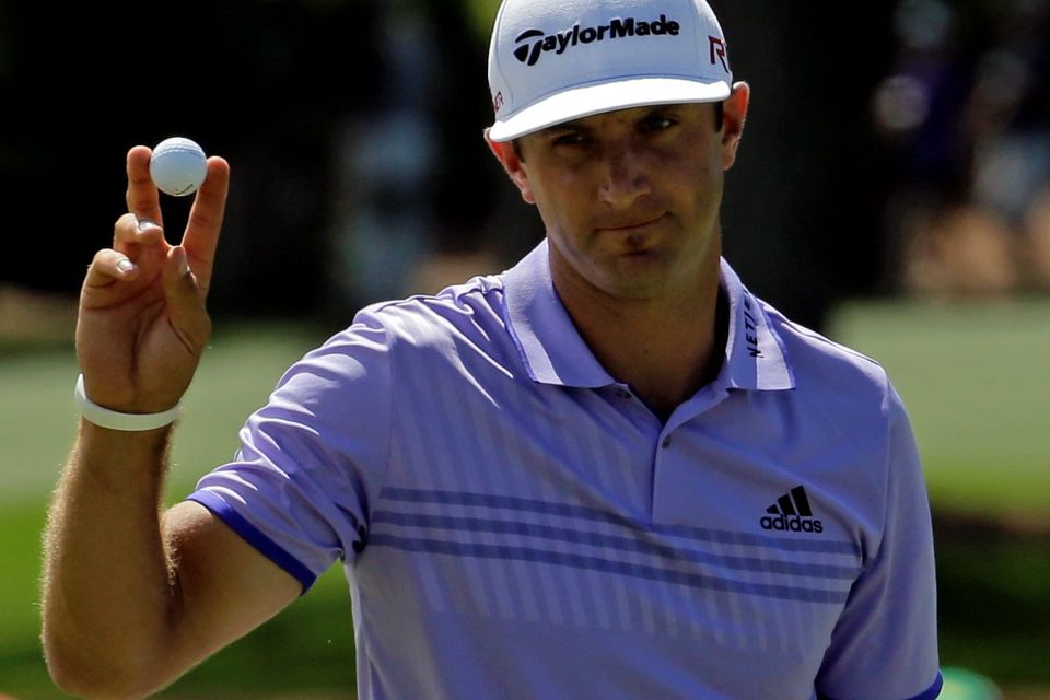 Dustin Johnson waves after a birdie on the second green during the third round of the Masters golf tournament