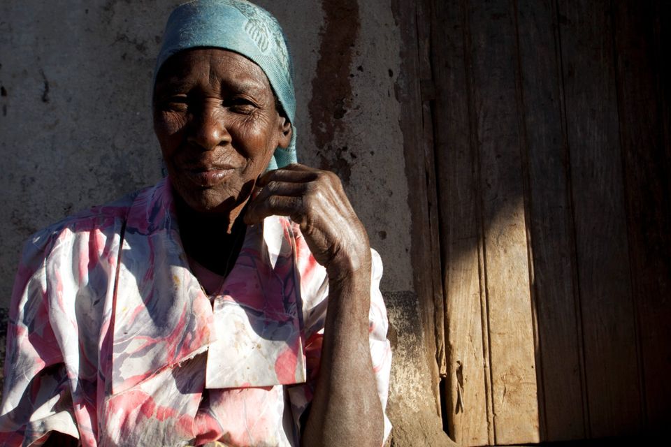 A woman sits outside her home in Lilongwe
