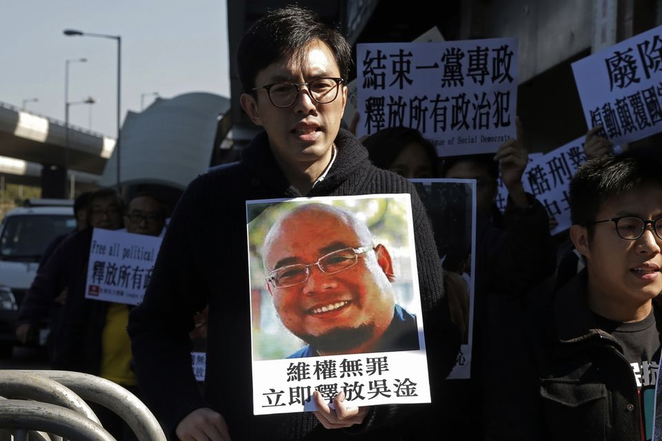 Pro-democracy activists hold pictures of Chinese activist Wu Gan in Hong Kong (Kin Cheung/AP)