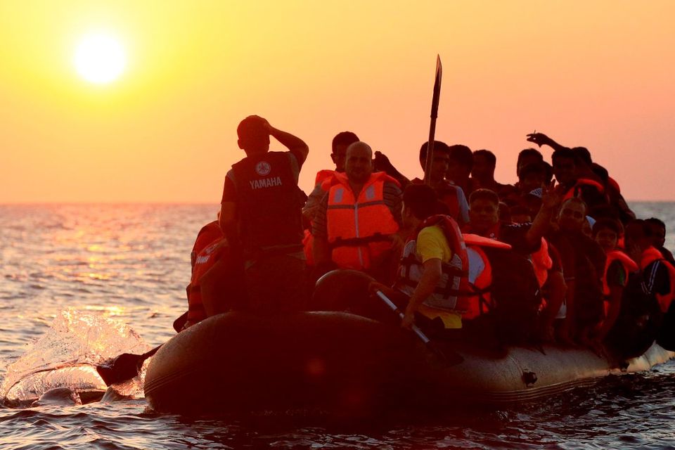 Migrants and refugees paddling a rubber dinghy approach the beach at Psalidi near Kos Town, Kos, Greece. PRESS ASSOCIATION Photo. Picture date: Friday August 21, 2015. See PA story POLITICS Kos. Photo credit should read: Jonathan Brady/PA Wire