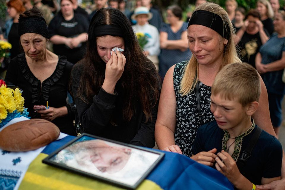 Relatives of Anton Savytskyi cry by his coffin during his funeral service yesterday in Bucha, Ukraine. Picture by Alexey Furman