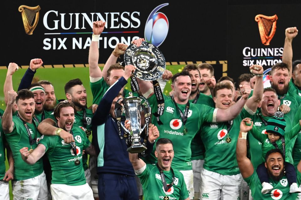 Ireland players celebrate with the Six Nations and Triple Crown trophies. Photo by Ramsey Cardy/Sportsfile