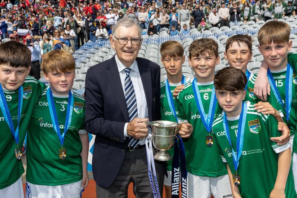 Corn Johnstone Mooney and O Brien: Oisín Mouthon, GS na Fuinseoga captain, receives the cup from Mr Pat Fogarty after their game with St Patrick’s SNS, Skerries