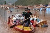 thumbnail: A family carry  their belongings along the Huatanay river in Cuzco, Peru (AP)