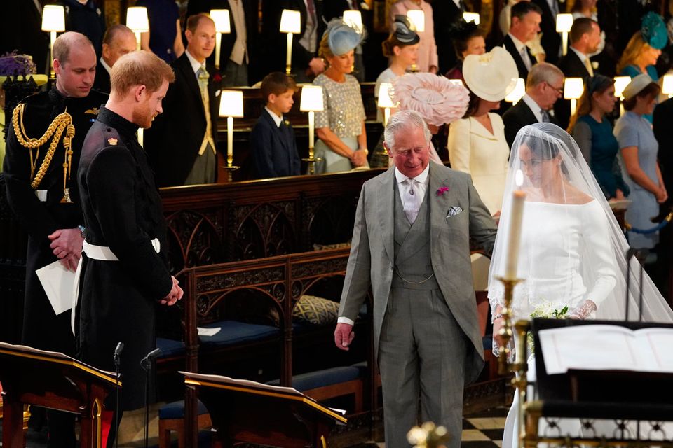 Prince Harry looks at his bride, Meghan Markle, as she arrives accompanied by Prince Charles, Prince of Wales during their wedding in St George's Chapel at Windsor Castle on May 19, 2018 in Windsor, England. (Photo by Jonathan Brady - WPA Pool/Getty Images)