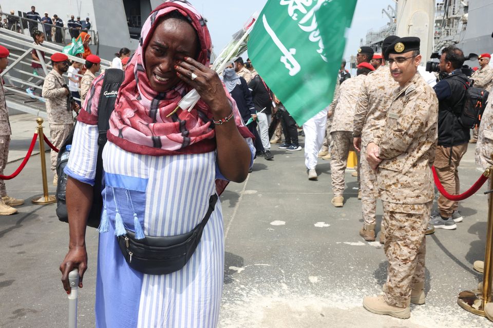 A woman disembarks from a navy ship with people evacuated to Saudi Arabia from Sudan. Photo: Reuters