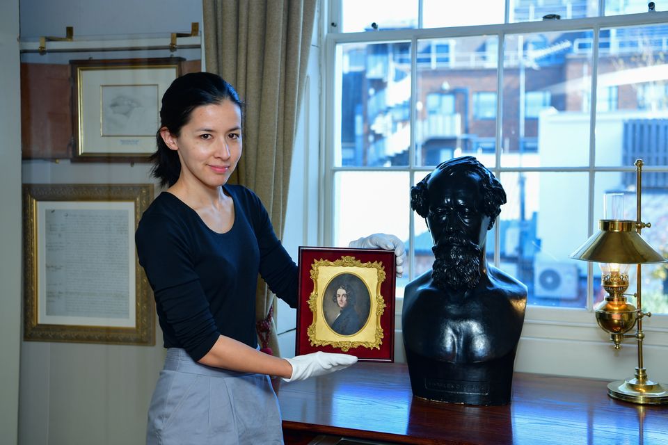 Louisa Price, curator at the Charles Dickens Museum, holds the portrait (Rebecca Brown/PA)