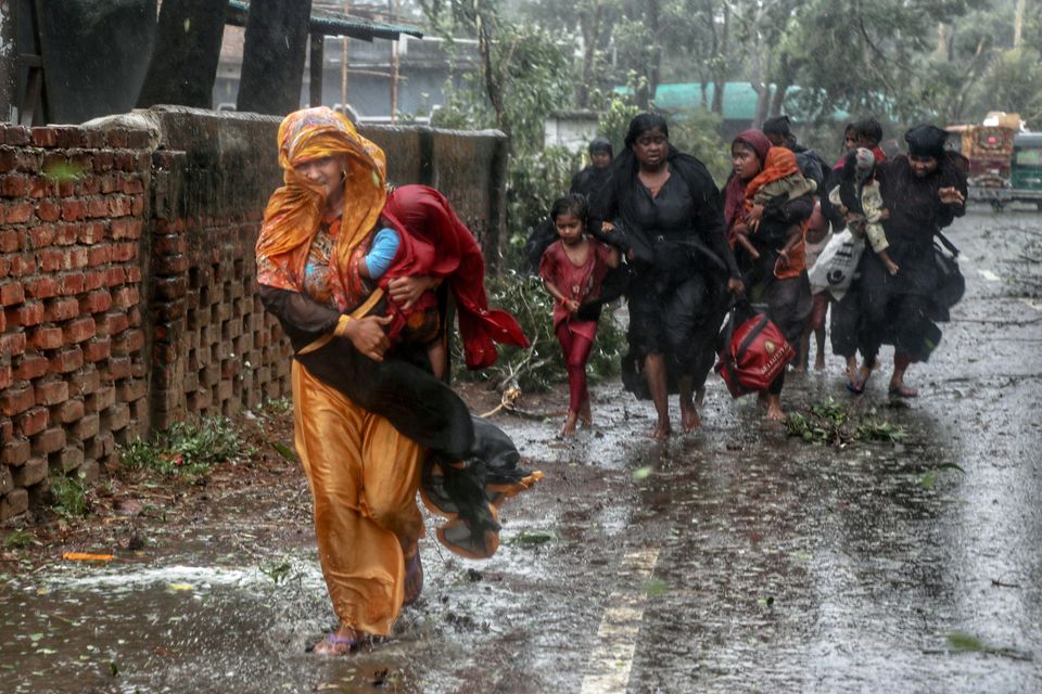 People leave their homes to take shelter during the landfall of cyclone Mocha in Teknaf, Bangladesh. Photo: Jibon Ahmed/Reuters