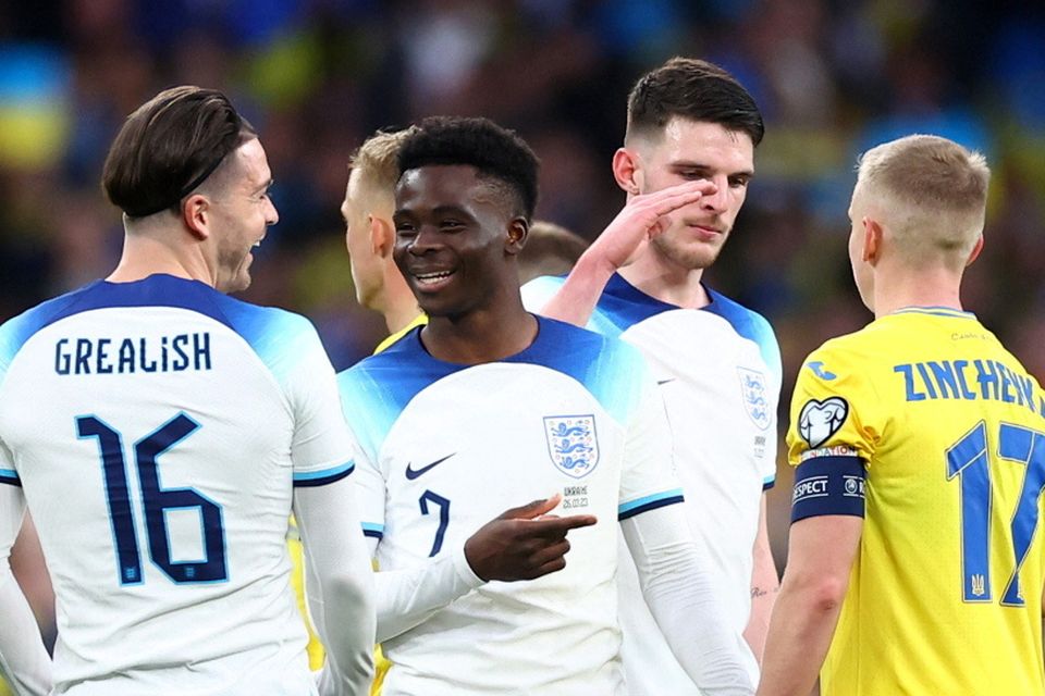 England's Jack Grealish and Bukayo Saka with Ukraine's Oleksandr Zinchenko after the match
