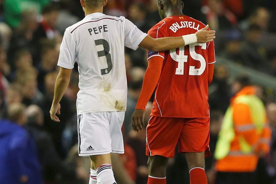 Liverpool's Mario Balotelli (R) walks off the pitch at half-time with Real Madrid's Pepe, before swapping shirts in the tunnel