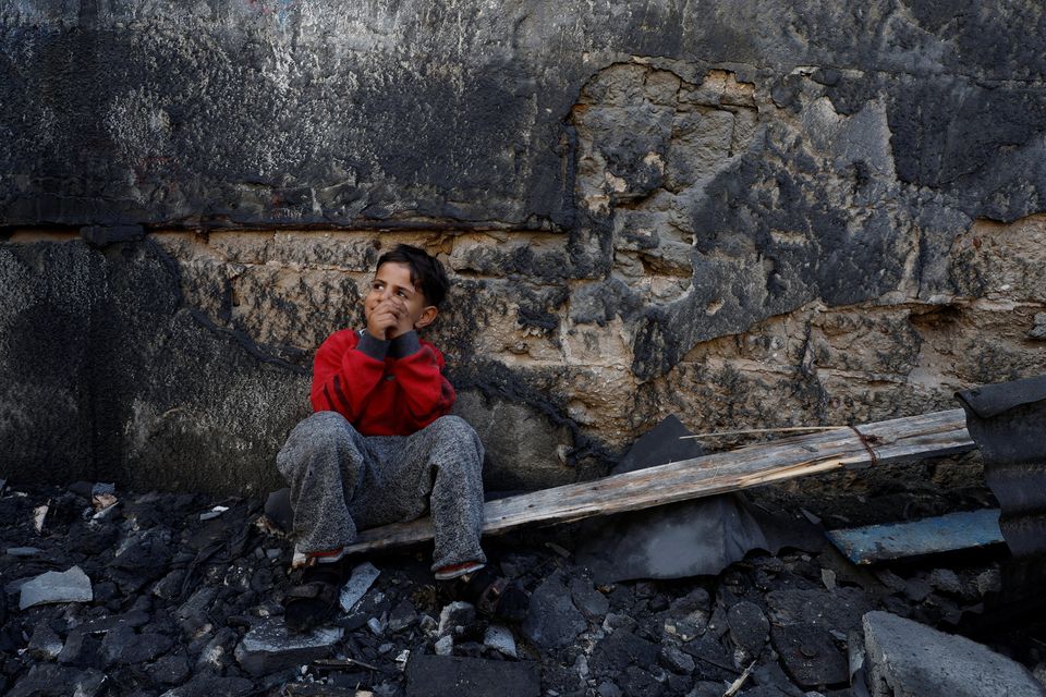 A Palestinian child sits near the site of Israeli strikes on houses in Khan Younis in the southern Gaza Strip. Photo: Reuters