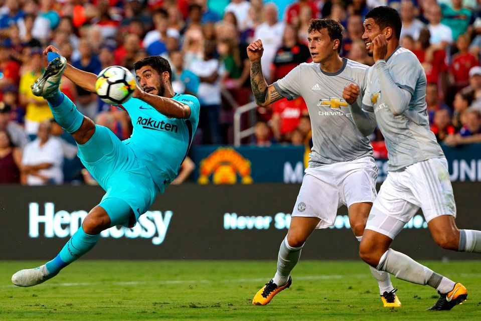 Luis Suarez shoots against Manchester United in the first half
