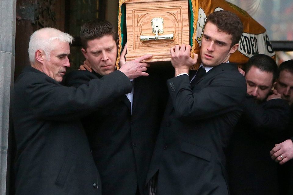 Grandson, Mikey Quinn, right helps to carry the coffin from St Marys Church, Killenaule, Co. Tipperary after the funeral of Billy Quinn