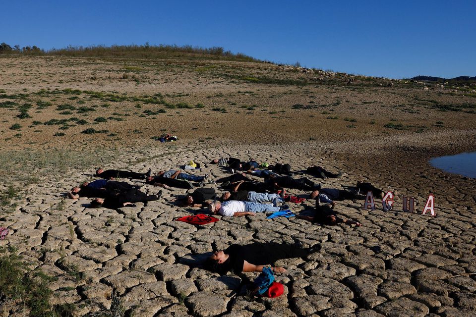 Protesters in Spain lie on the cracked ground of a reservoir near Malaga. Photo: Jon Nazca/Reuters