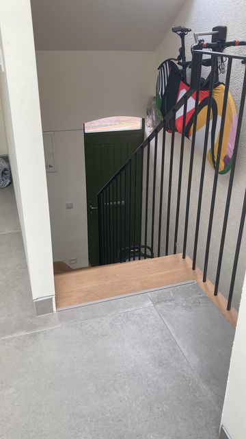 The couple hangs their bike with a Maser cover, doubling as art work in the hallway