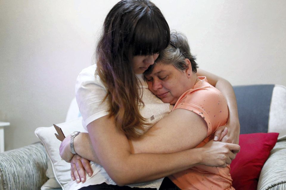 Daughter Michelle Gomes (L) and wife Jacquita Gonzales of in-flight supervisor Patrick Francis Gomes, who was aboard the missing Malaysia Airlines Flight MH370, comfort each other at their home in Kuala Lumpur.