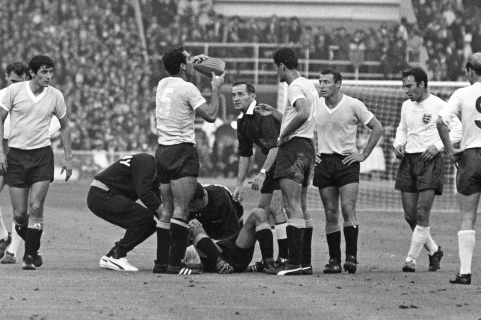 A Uruguayan player receives treatment for an injury during the opening match of the 1966 World Cup at Wembley Stadium between England and Uruguay, while Nestor Concalves takes a drink, also seen are Jimmy Greaves and Bobby Charlton. Photo: Cattani/Fox Photos/Hulton Archive/Getty Images