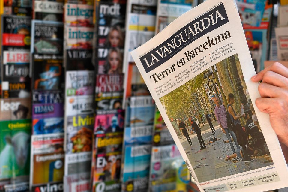 A person reads the Catalan newspaper La Vanguardia on August 18. Photo - GABRIEL BOUYS/AFP/Getty Images
