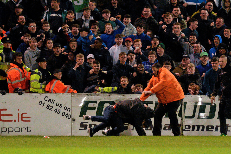 Spectators look on as stewards rush to control two fans who ran on to the pitch and began fighting. Photo: Sportsfile