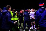 thumbnail: Members of both teams and backroom staff tussle at the final whistle