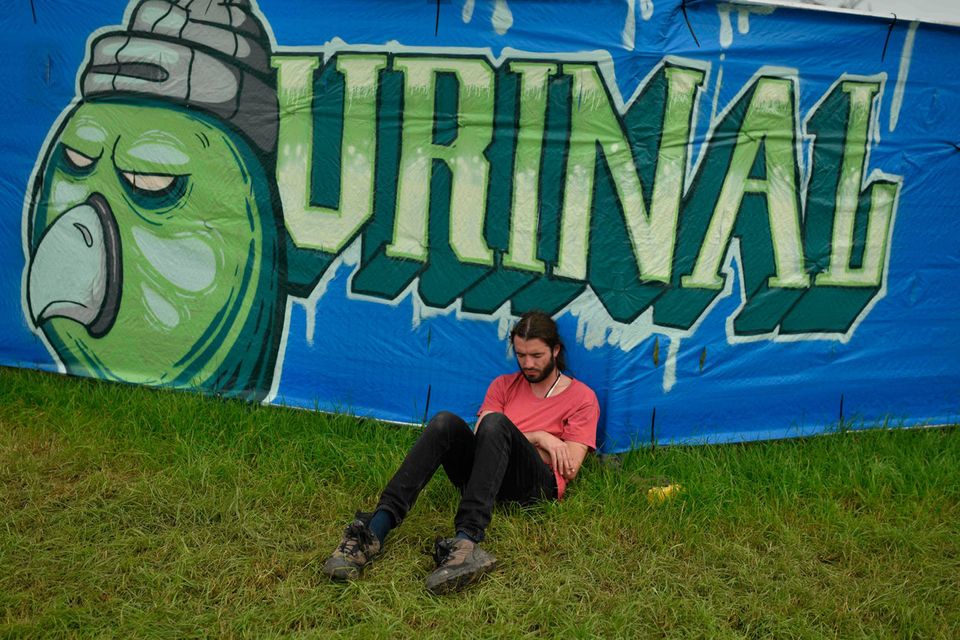 A reveller sits in the grass at the Glastonbury Festival of Music and Performing Arts on Worthy Farm near the village of Pilton in Somerset, South West England, on June 26, 2019. (Photo by Oli SCARFF / AFP)OLI SCARFF/AFP/Getty Images