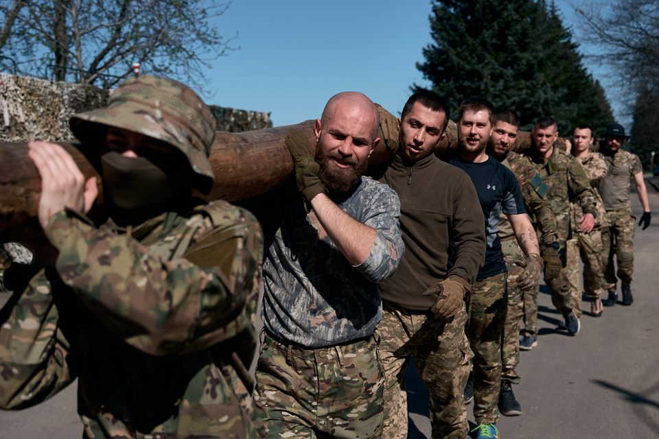 Ukrainian army recruits take on an obstacle course as they undergo military training at a recruiting centre in Kyiv. Photo: Getty