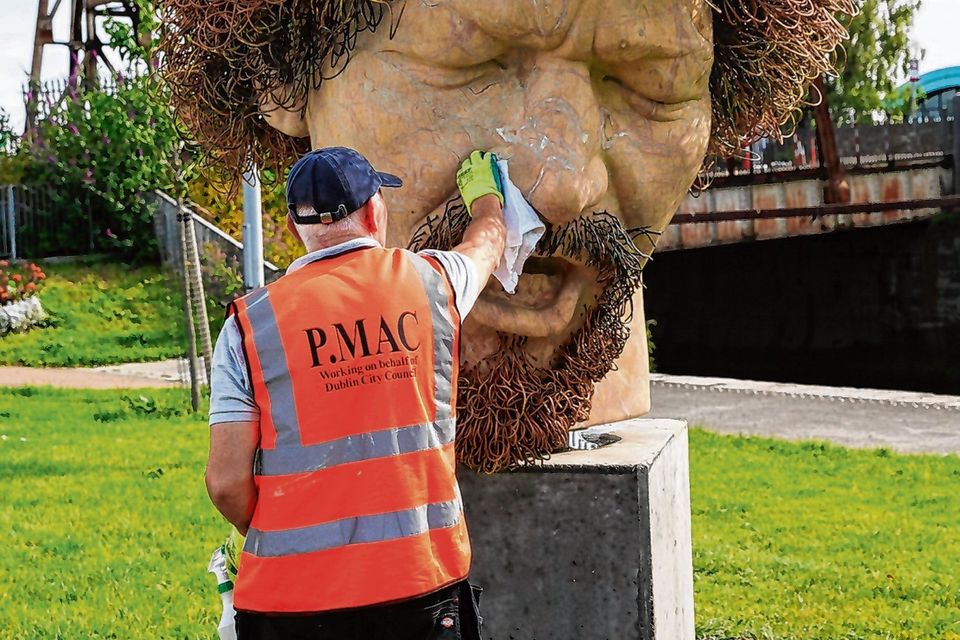 A worker removing graffiti on the Luke Kelly statue
