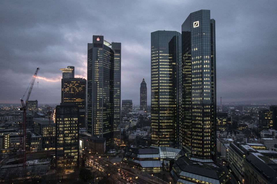 The twin tower skyscraper headquarter offices of Deutsche Bank, right, stand at dusk in Frankfurt