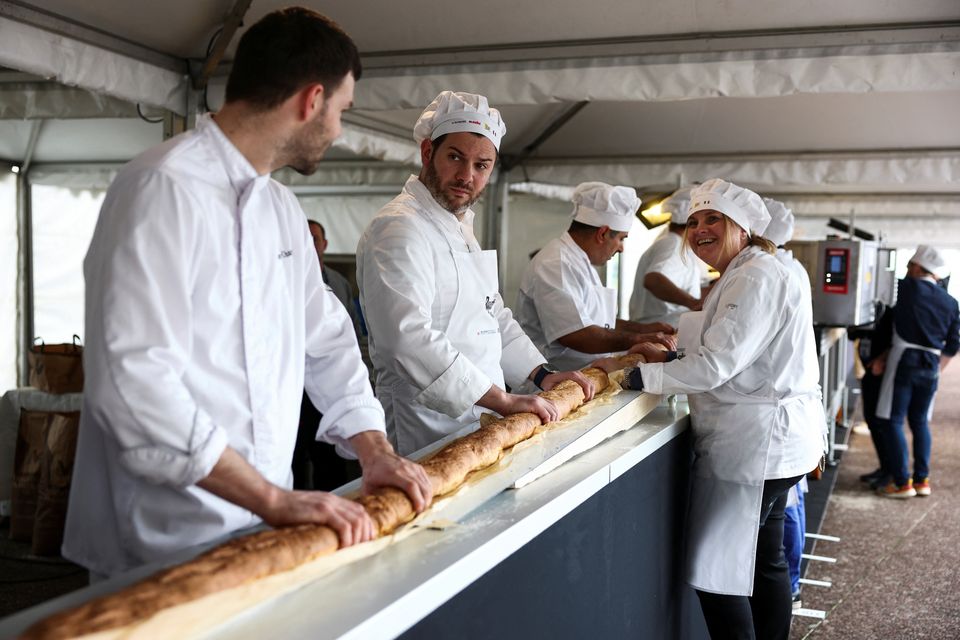 French bakers stand near a large rotating oven in an attempt to beat the world record for the longest baguette during the Suresnes Baguette Show in Suresnes near Paris, France, May 5, 2024. REUTERS/Stephanie Lecocq