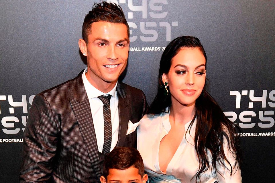 Real Madrid and Portugal forward Cristiano Ronaldo (L) poses for a photograph with partner Georgina Rodriguez (R) and his son Cristiano Ronaldo Jr as he arrives for The Best FIFA Football Awards ceremony, on October 23, 2017 in London. / AFP PHOTO / Glyn KIRKGLYN KIRK/AFP/Getty Images