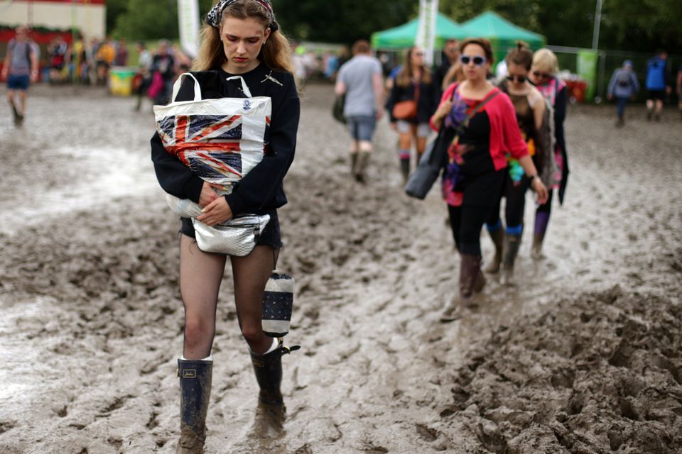 Festivalgoers make their way through the mud