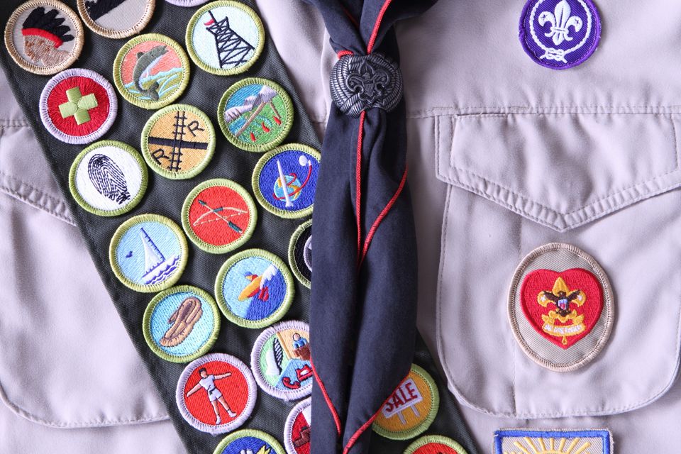 "Placentia CA, USA- October 18, 2012: Close up of Boy Scout uniform shirt with Life rank patch (with red heart) on right side and merit badges on merit badge sash.  Included merit badges are pathfinding, carpentry, first aid, fishing, pioneering, fingerprinting, railroading, wilderness survival, small boat sailing, archery, space exploration, leatherwork, motorboating, automoto maintenance, personal fitness, communications, electicity, citizenship in the nation, and salesmanship, The Life Rank (shown) is the second highest rank in the Boy Scouts, second only to the Eagle rank."
