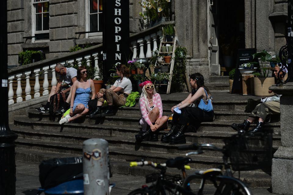 People enjoy a sunny afternoon on the steps near the entrance to Dublin's Powerscourt Center. On Monday, 21 June 2021, in Dublin, Ireland.