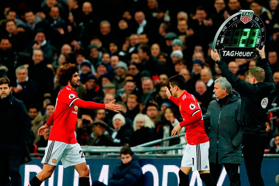 Manchester United's Belgian midfielder Marouane Fellaini (L) goes by manager Jose Mourinho (R) as he leaves the pitch to be replaced by Spanish midfielder Ander Herrera (C) at Wembley Stadium in London, on January 31, 2018. / AFP PHOTO / Adrian DENNIS /