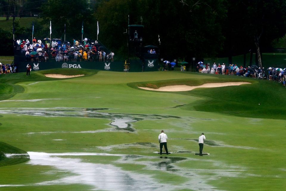 Members of the grounds crew squeegee the first fairway during a weather-delayed final round of the US PGA Championship at Valhalla. Photo: Sam Greenwood/Getty Images