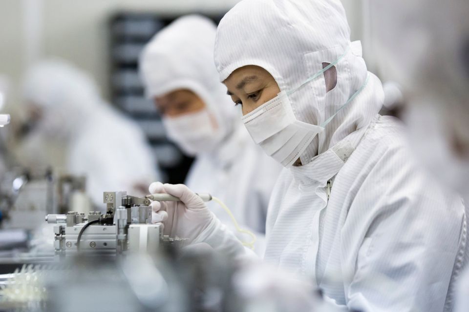 Employees assemble sample lens units for smartphones at the Kantatsu factory in Sukagawa, Fukushima, Japan
