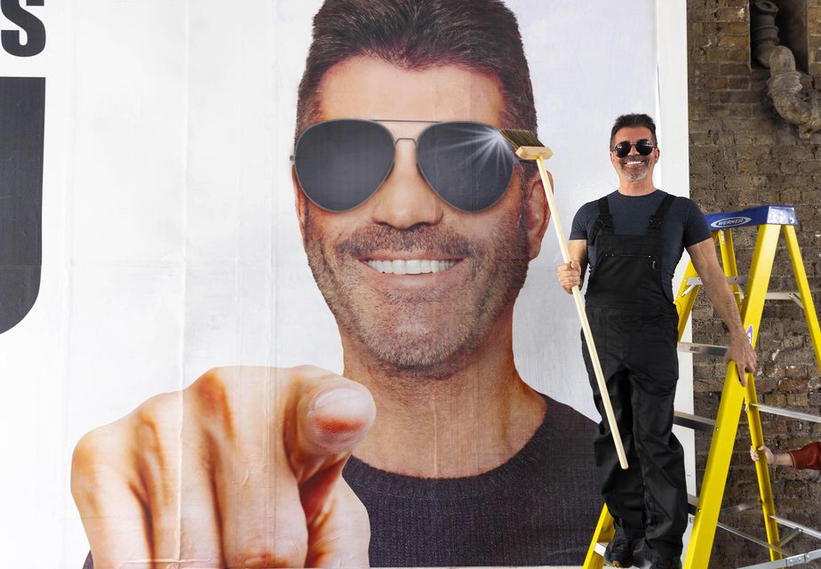 Cowell with his billboard (David Parry/PA)