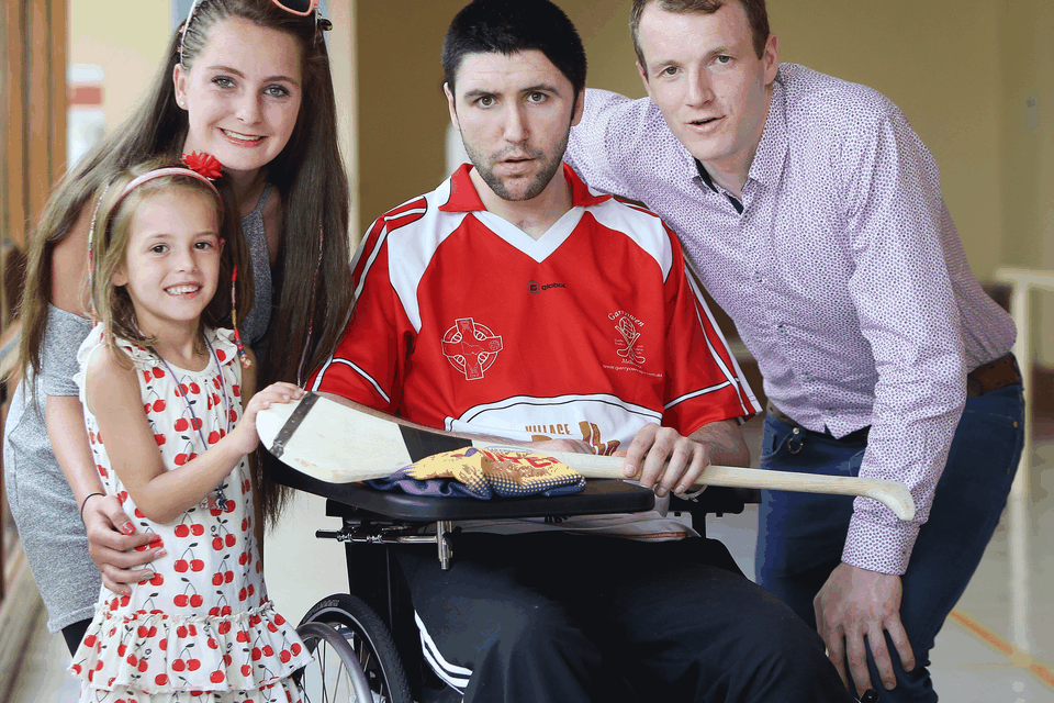 Shane Vickers (27), from Kilmacanogue, Co Wicklow, with his sisters Emily (16) and Keelin (6) and Tipperary hurler Lar Corbett at the National Rehabilitation Hospital in Dun Laoghaire