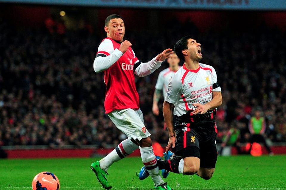 Liverpool's Uruguayan striker Luiz Suarez is brought down by Arsenal's English striker Alex Oxlade-Chamberlain during the English FA Cup fifth round football match between Arsenal and Liverpool at The Emirates Stadium, February 16, 2014